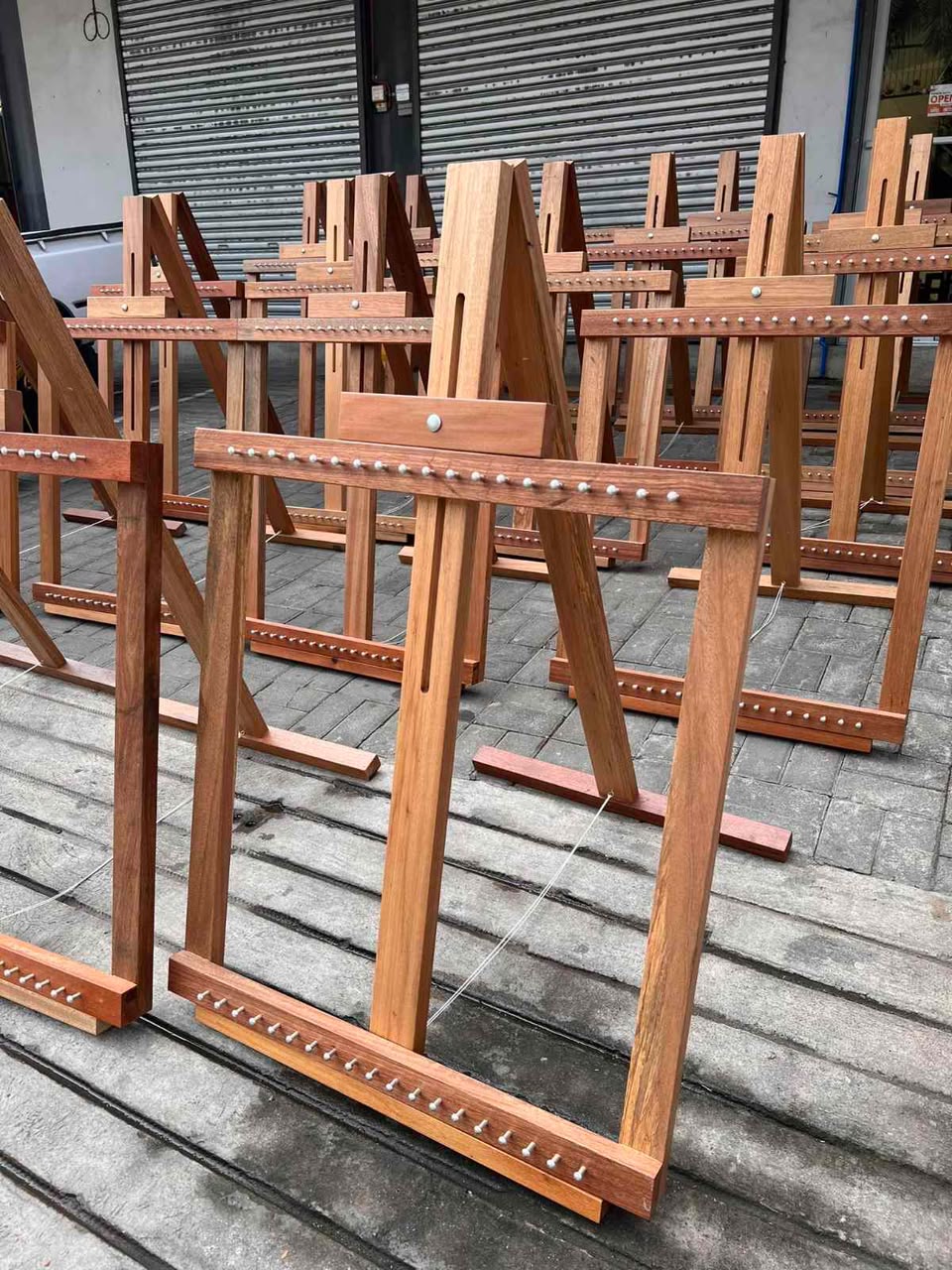 Wooden tapestry handloom frames with rows of metal pegs and adjustable crossbars.