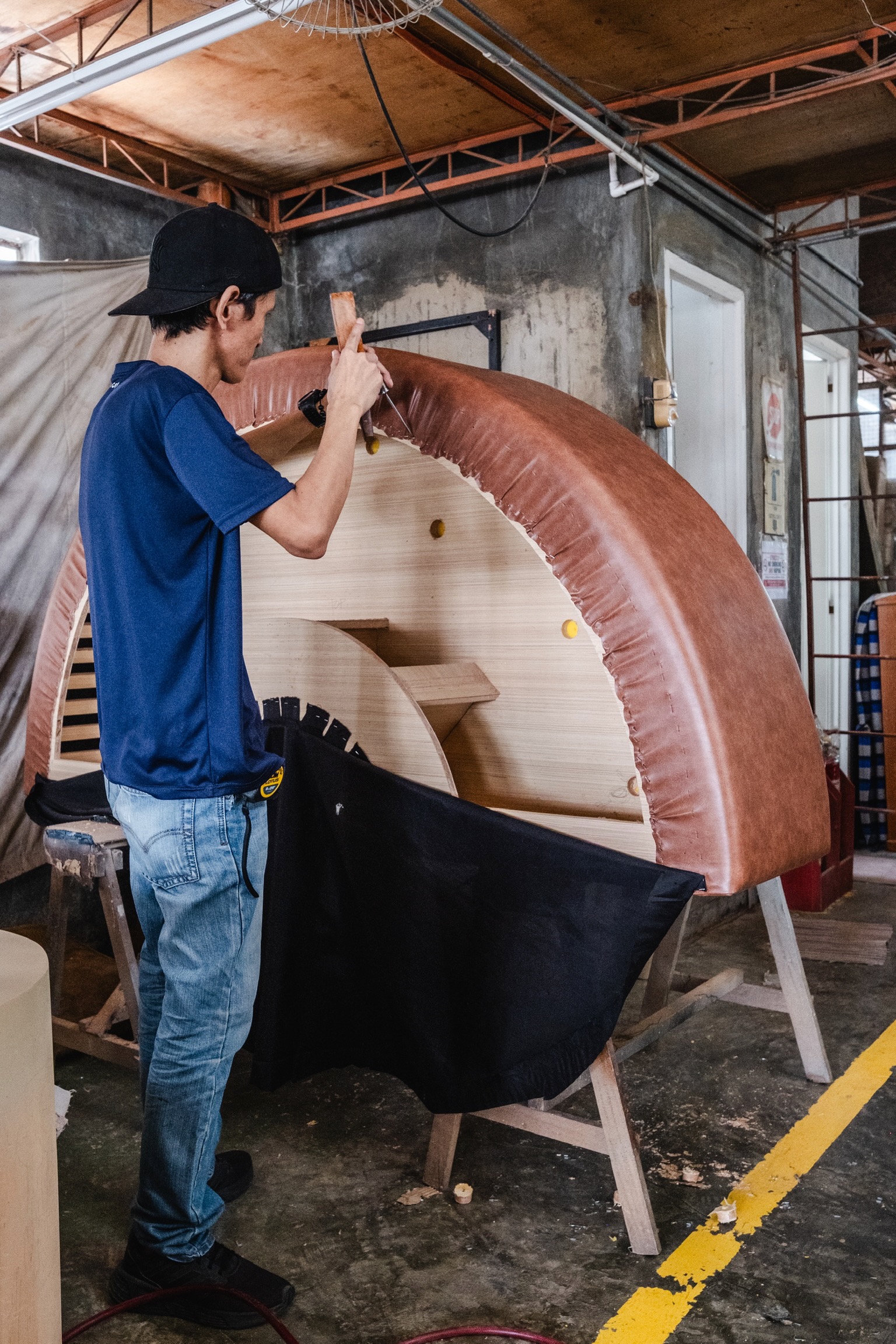 Danilyns craftsperson hand-finishing curved upholstery in the workroom